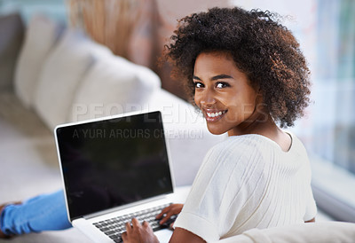 Buy stock photo Over the shoulder shot of a young woman using a laptop at home