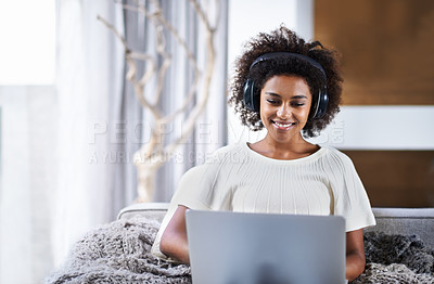 Buy stock photo Laptop, music and smile with afro black woman on sofa in living room of home for social media browsing. Computer, streaming and headphones with happy young person in apartment for weekend comfort
