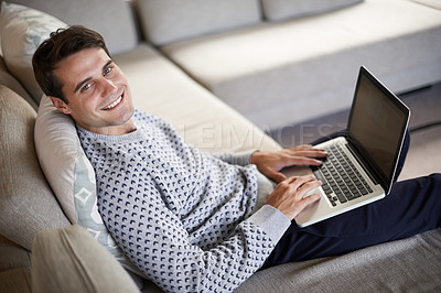 Buy stock photo Above, portrait or man on laptop for remote work, article post or networking in home to relax. Research, smile or happy male person on sofa typing online on technology for business, email or news