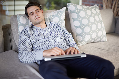Buy stock photo Shot of a man sleeping on his sofa with his laptop on his lap
