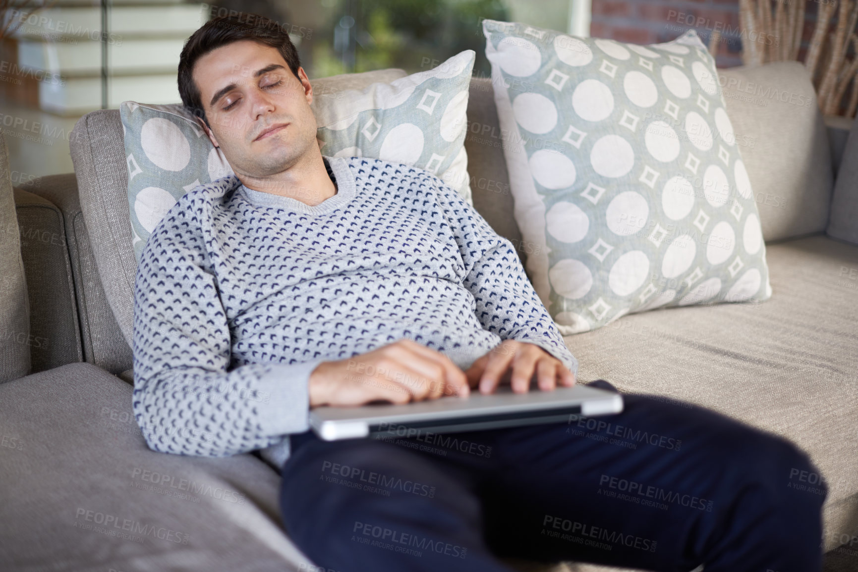 Buy stock photo Shot of a man sleeping on his sofa with his laptop on his lap