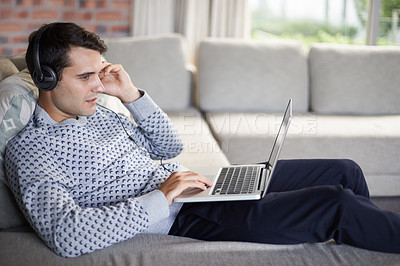 Buy stock photo Relax, headphones or man on laptop for streaming movies, music or film series in home to research. Podcast, radio or person on sofa listening online on technology for digital blog or playlist on web
