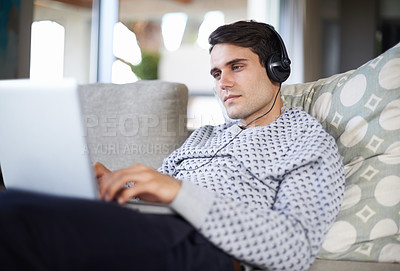Buy stock photo Research, headphones or man on laptop for streaming movies, music or film series in home to relax. Podcast, radio or person on sofa listening online on technology for digital blog or playlist on web