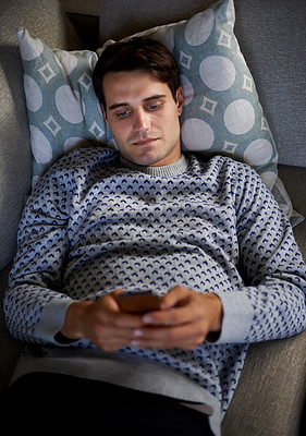 Buy stock photo Home, night or above of man on a phone for social media blog, post or network on a sofa. Streaming movie, mobile app or person online for texting on technology for article, email or news to relax