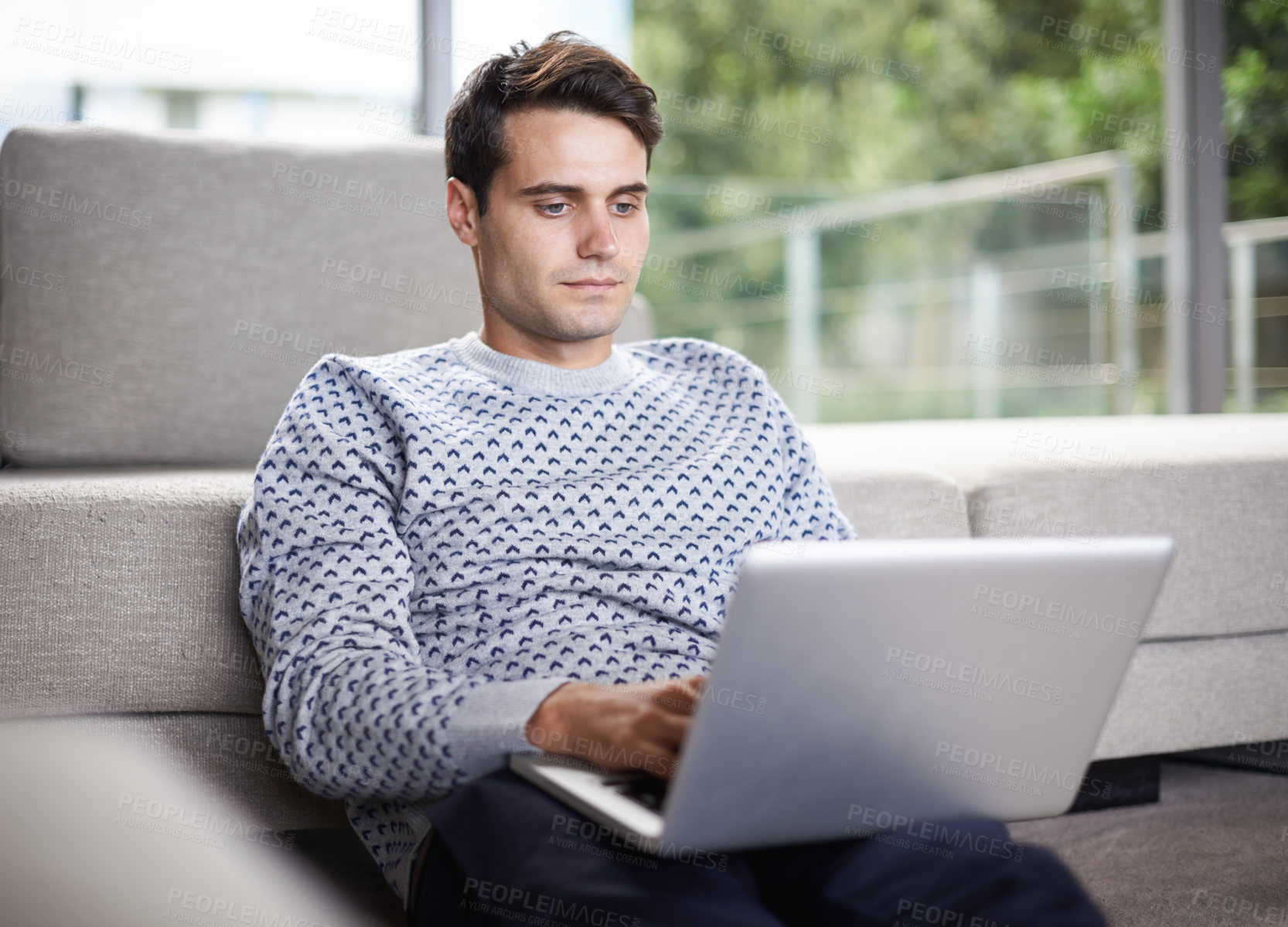 Buy stock photo Man, home and couch with typing on laptop for remote work as freelancer with startup business and online research. Male person, living room and browse on internet with information for project