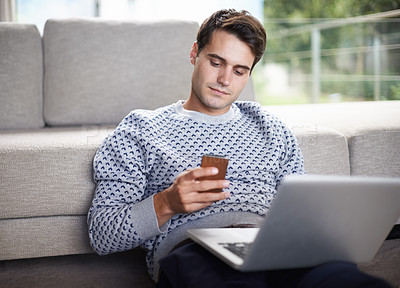 Buy stock photo Man, phone and relax with sofa in living room for tech, social media and research in home or indoor on weekend. Male person or freelancer and looking on screen for browse with internet and online