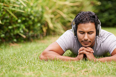 Buy stock photo Man, outdoor and headphones on grass, peace and meditating outside for wellness in nature. Male person, backyard and tech to relax, listen and vacation at home or house for peace in music or podcast