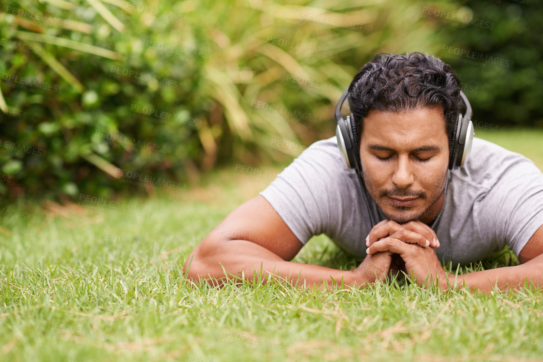 Buy stock photo Man, outdoor and headphones on grass, peace and meditating outside for wellness in nature. Male person, backyard and tech to relax, listen and vacation at home or house for peace in music or podcast