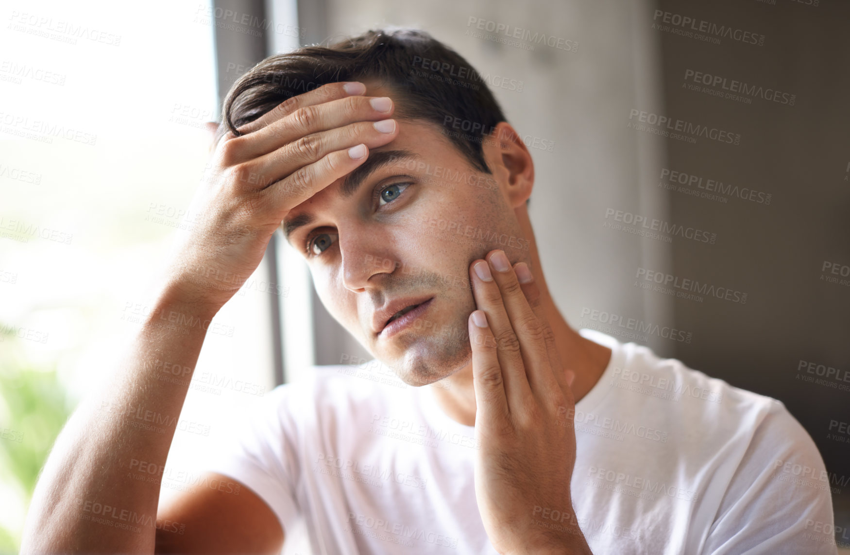 Buy stock photo Cropped shot of a young man feeling his face for stubble