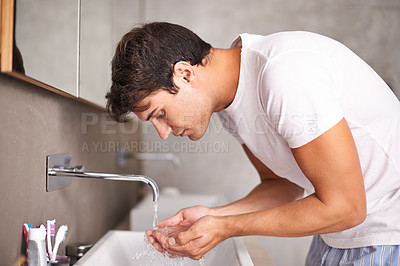 Buy stock photo Shot of a young man catching water in his hands