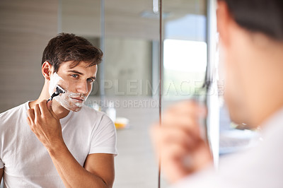 Buy stock photo Mirror, shaving and face of man in bathroom for facial grooming, wellness and skincare at home. Health, skincare and serious male person shave beard for hygiene, cleaning and hair removal with razor