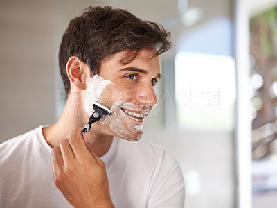Buy stock photo Cropped shot of a young man shaving his facial hair with a disposable blade