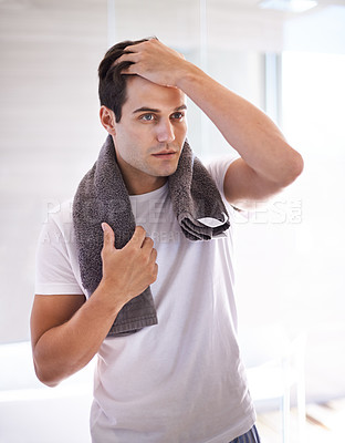 Buy stock photo Cropped shot of a young man in the bathroom with a towel around his neck