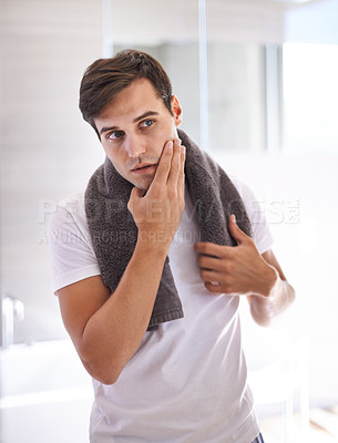 Buy stock photo Skincare, shaving and face of man in bathroom for facial grooming, wellness and cosmetics at home. Health, dermatology and serious male person for hygiene, cleaning and hair removal with beauty cream