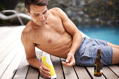 Buy stock photo Body, care and man with sunscreen application at a poolside for swimming, fun or sunbathing with beer. Skincare, protection and male person with spf product, cream or lotion for skin safety on a deck