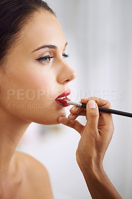 Buy stock photo Cropped shot of a beautiful woman having lipstick applied with a makeup brush