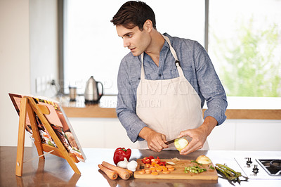 Buy stock photo Cooking, man and cookbook in a kitchen with food, vegetables and ingredients for meal. Reading, male person and healthy diet in a house for nutrition eating and chef learning with a book and knife