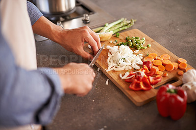 Buy stock photo Cropped shot of a man chopping vegetables on a countertop