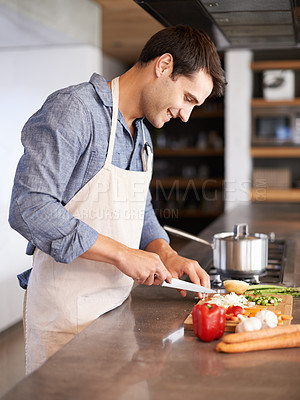 Buy stock photo Cooking, man and smile in a kitchen with food, vegetables and ingredients for meal. Happy, male person and healthy diet in house for nutrition eating and chef learning with wellness from chopping