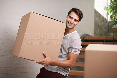 Buy stock photo A happy young man moving packed cardboard boxes in his home
