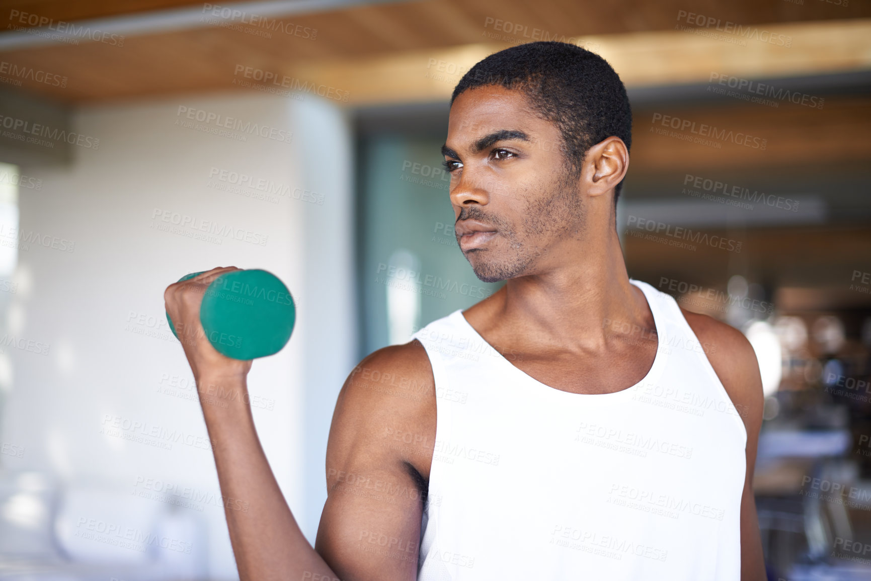 Buy stock photo A fitness shot of a young man toning with weights