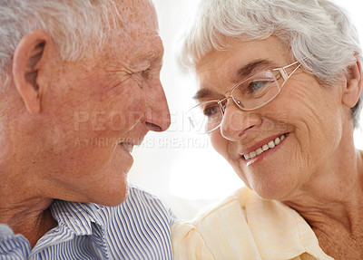 Buy stock photo Couple, senior and happy or love in looking, home and relax together for bonding and smile. Elderly people, romance and care in marriage or relationship in retirement, closeup and security in house