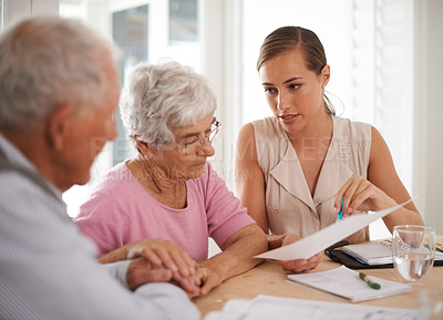Buy stock photo A young businesswoman explains information to an elderly couple