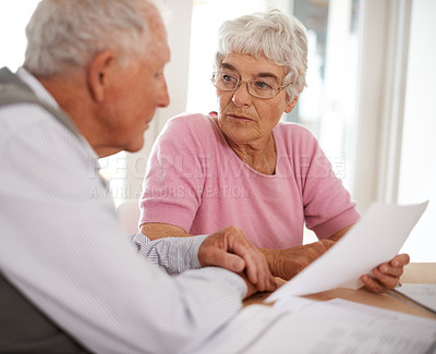 Buy stock photo Shot of two elderly people discussing a document