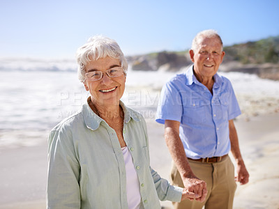 Buy stock photo Senior, couple and holding hands on beach for portrait on retirement vacation or anniversary to relax with love, care and commitment with support. Elderly man, woman and together by ocean for peace.