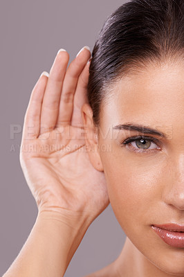 Buy stock photo Beauty shot of a young woman with a cupped hand behind her ear