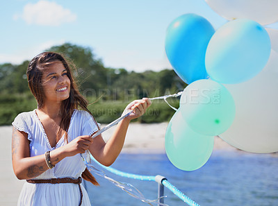 Buy stock photo Woman, happy and hold balloons on beach for freedom on holiday season or travel, relax and carefree with joy. Female person, outdoors and helium for celebration or birthday on summer vacation.