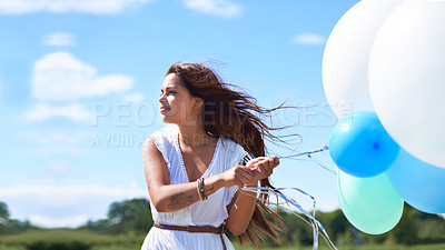 Buy stock photo Cropped shot of a gorgeous tattooed young woman holding balloons