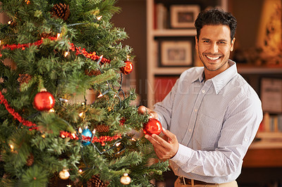 Buy stock photo Happy man, portrait and Christmas tree with decor or bauble for festive, celebration or December at home. Male person with smile, ornament or interior decoration for traditional season or new year
