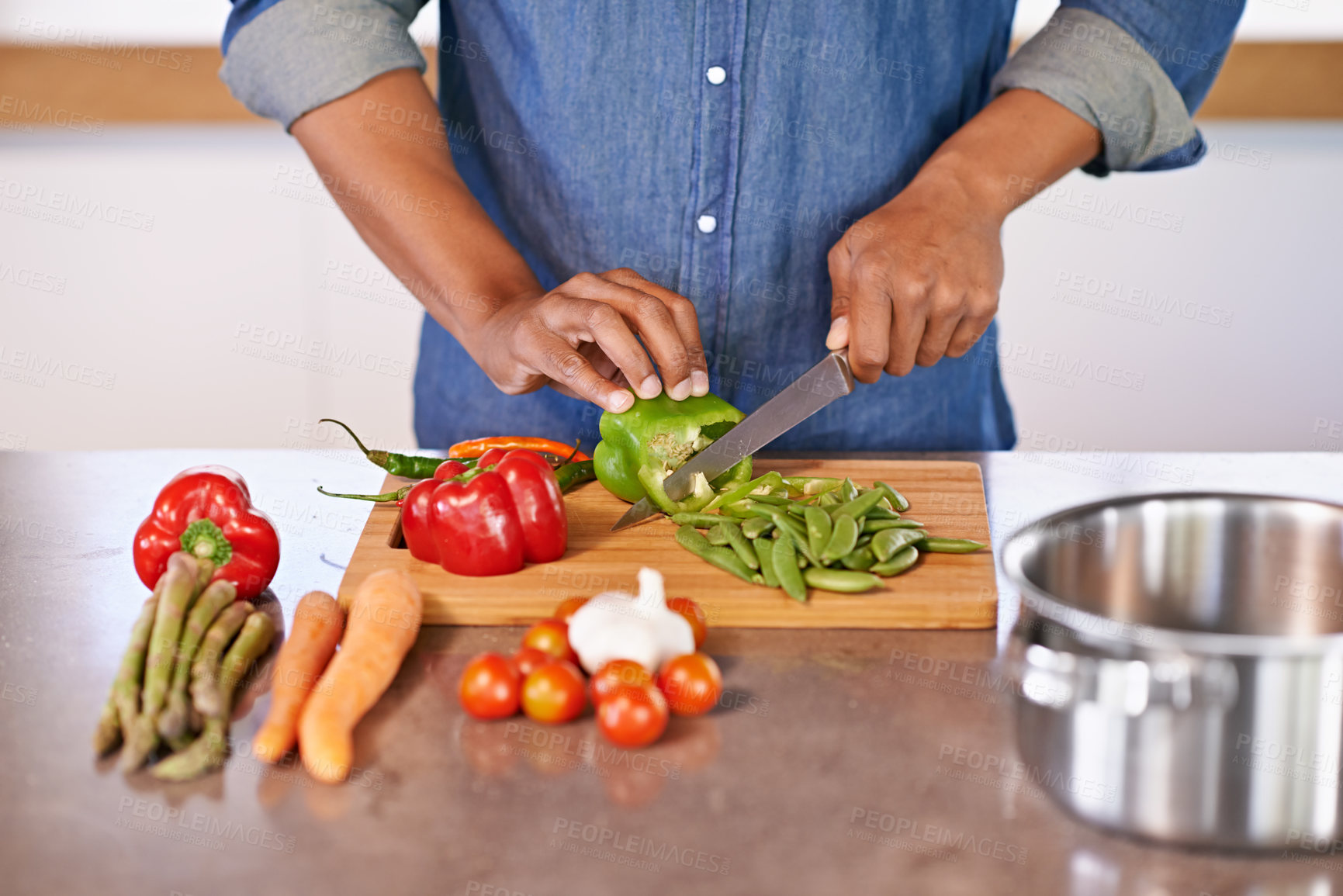 Buy stock photo Cropped view of a man chopping some fresh vegetables on the kitchen counter