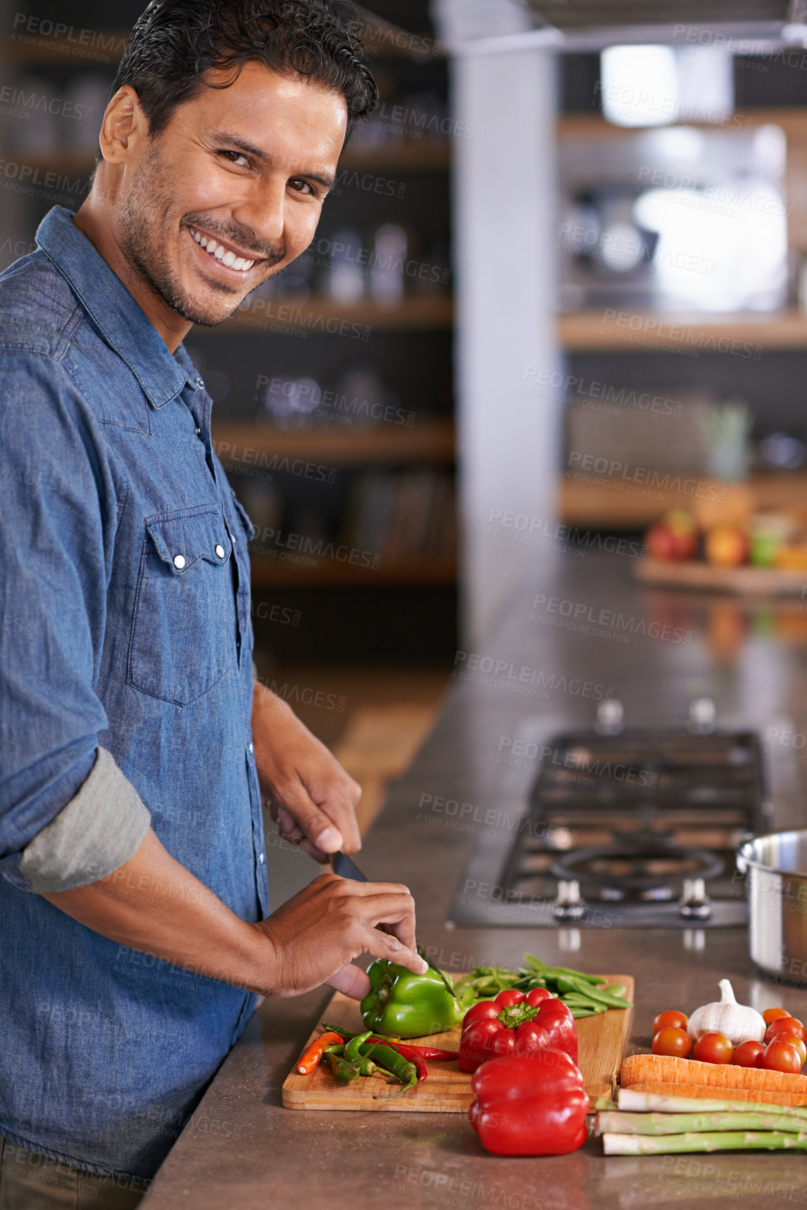 Buy stock photo Food, home and cooking for man in kitchen with vegetables on counter for health, diet or recipe for dinner. Chef, vegan and smile with knife and ingredients on board for soup, eating and mockup 