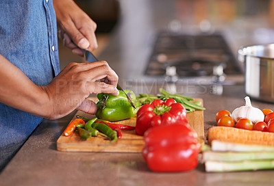 Buy stock photo Cropped view of a man chopping vegetables on the kitchen counter