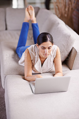 Buy stock photo Laptop, internet and social media with woman on sofa in living room of apartment for research or browsing. Computer, relax and technology with person typing email, report or article for online blog