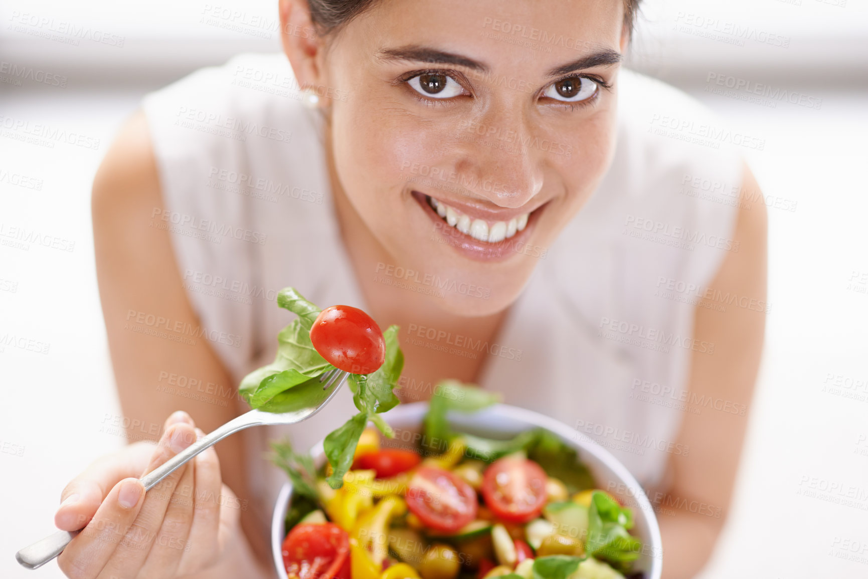 Buy stock photo High angle portrait of an attractive young woman eating a bowl of salad