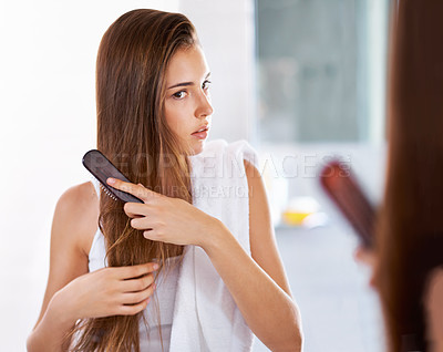 Buy stock photo Reflection, woman and brush hair in bathroom at home for beauty, care or morning routine with cosmetics. Mirror, hairstyle and serious person combing for cleaning, grooming or treatment for wellness