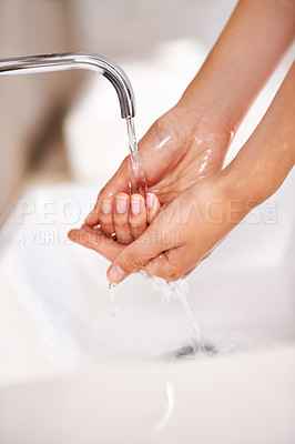 Buy stock photo Shot of a young woman washing her hands in a bathroom