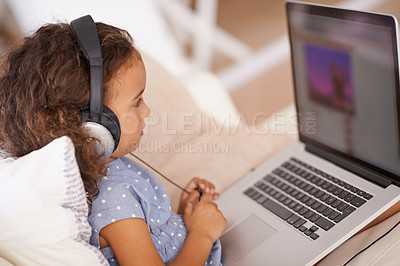 Buy stock photo Elearning, video and kid on laptop in home with online class, website and girl with headphones. Virtual, education and child streaming course on sofa in house for development of language knowledge
