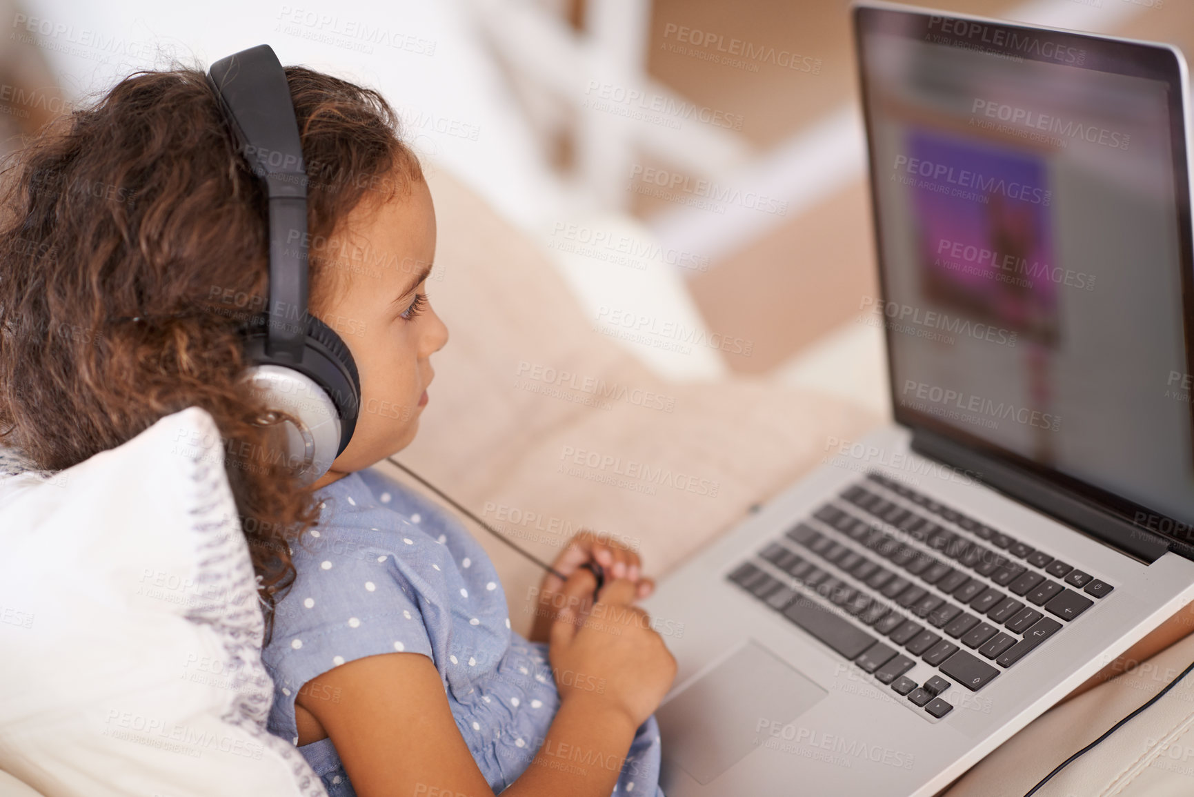 Buy stock photo Elearning, video and kid on laptop in home with online class, website and girl with headphones. Virtual, education and child streaming course on sofa in house for development of language knowledge
