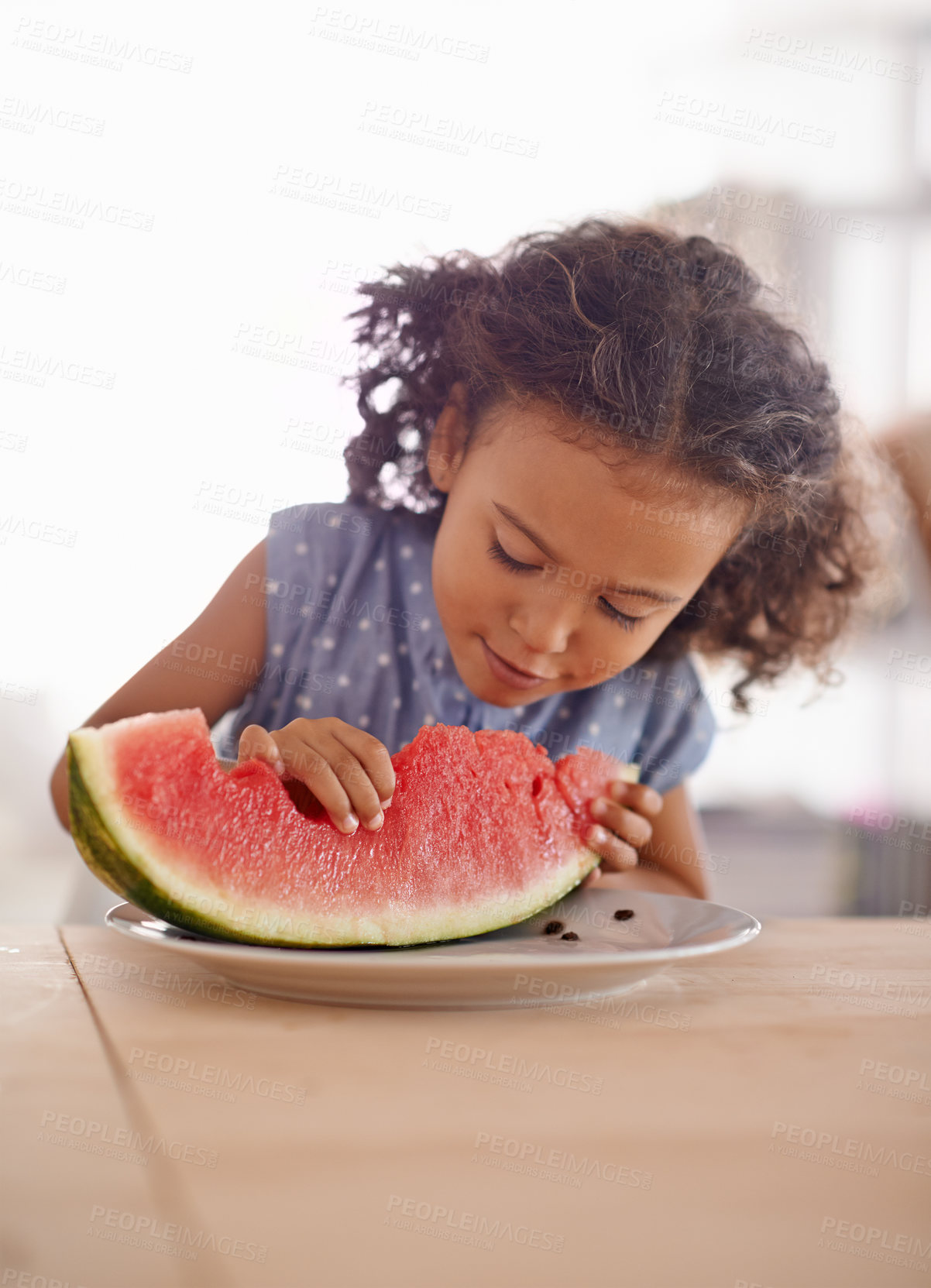 Buy stock photo Child, eating and hungry with watermelon in home, nutrition and healthy food on table in kitchen. Girl, organic fruit and happy for snack in summer on vacation, wellness and vitamins for development
