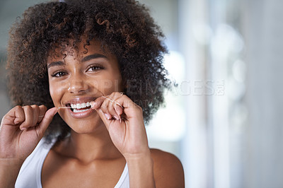 Buy stock photo Shot of a young woman flossing her teeth in the mirror