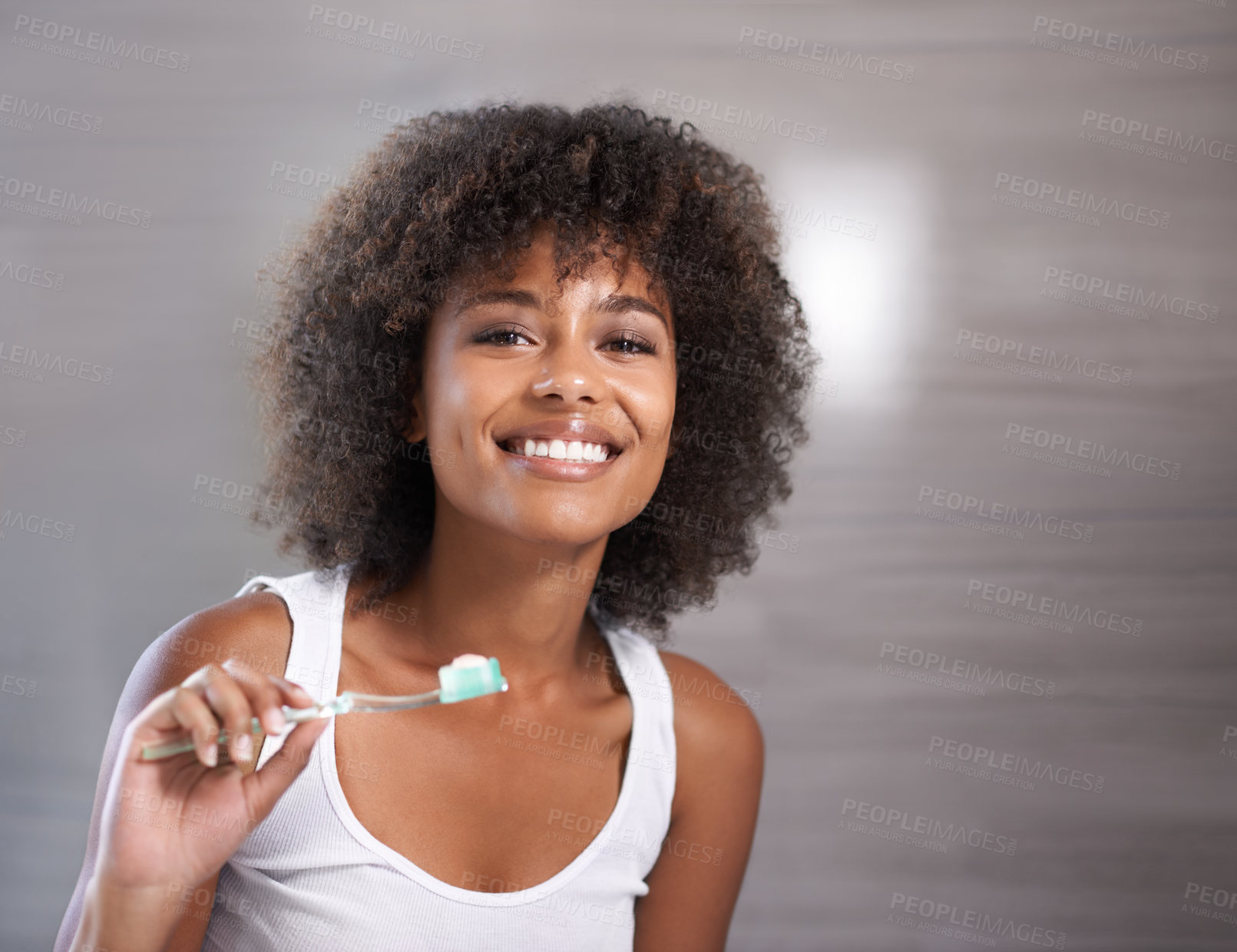 Buy stock photo Shot of a a young woman brushing her teeth