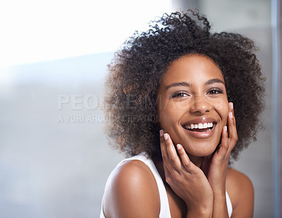 Buy stock photo Portrait of an attractive young woman giving you a toothy smile while touching her skin