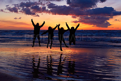 Buy stock photo Silhouette of a group of people jumping on the beach at sunset