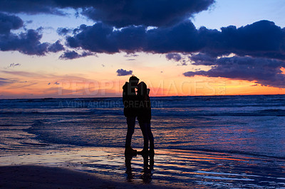 Buy stock photo Silouehette of a couple kissing on the beach at sunset