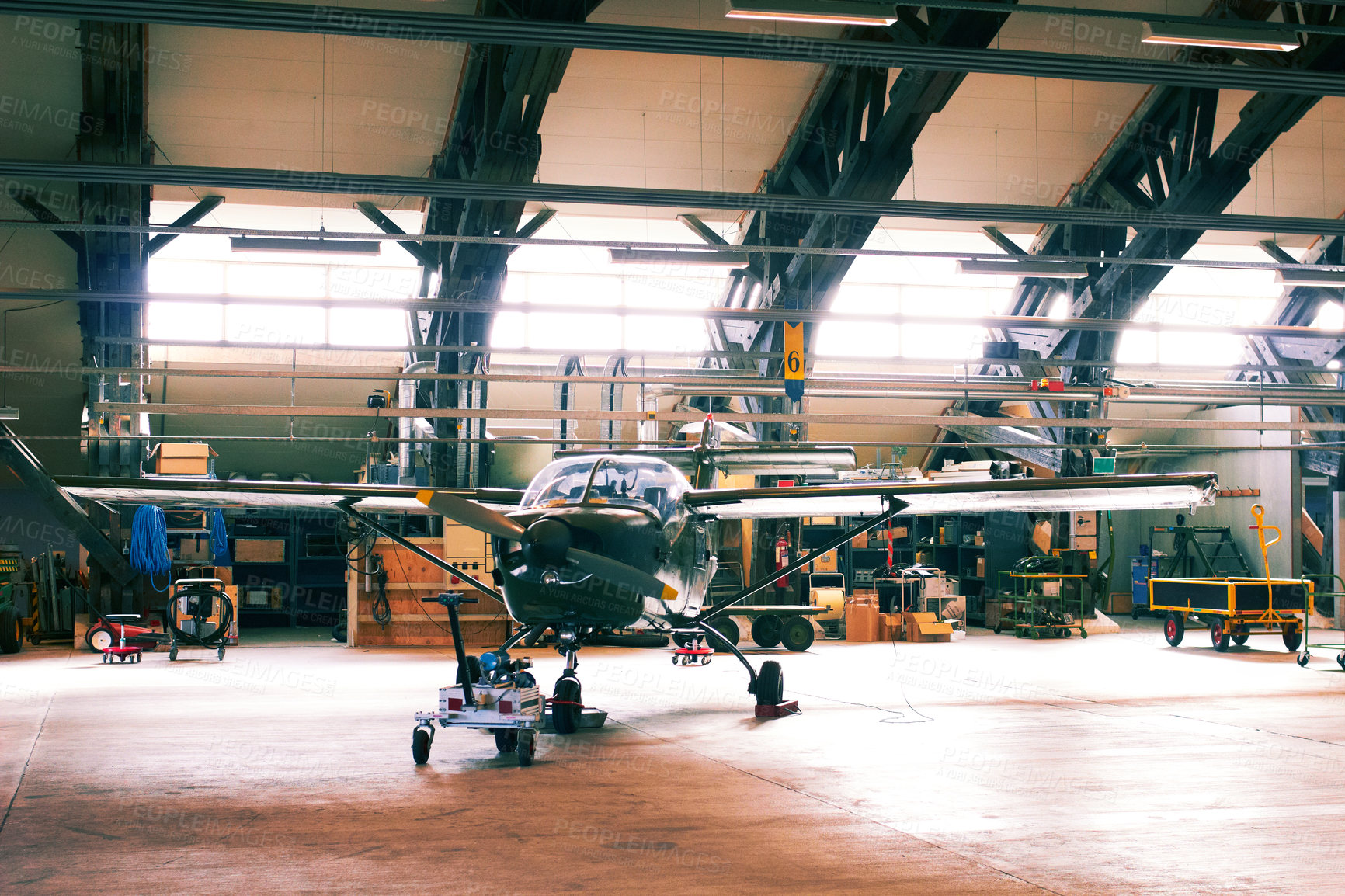 Buy stock photo Shot of a light aircraft in a hanger