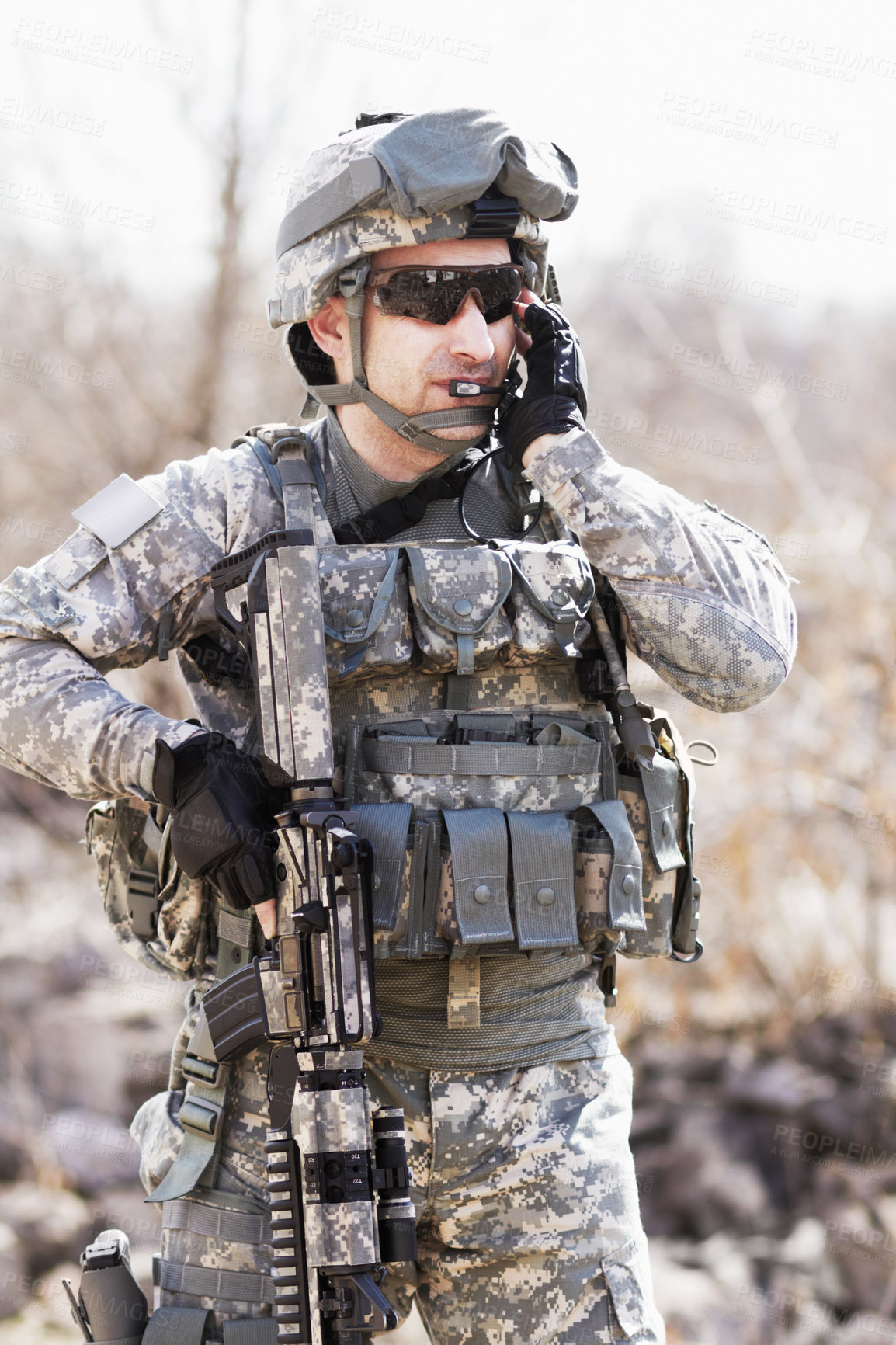 Buy stock photo A soldier crouched down next to a broken down wall and pointing his gun into the distance